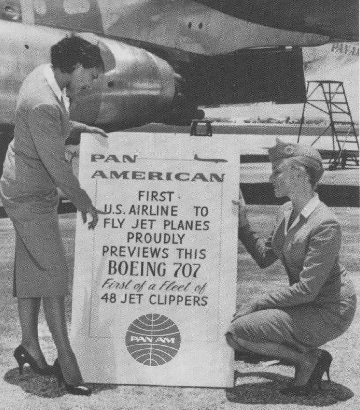 1950s Two stewardesses review a sign by an early Pan Am jet Clipper
